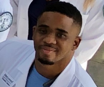 A young man wearing a white coat.